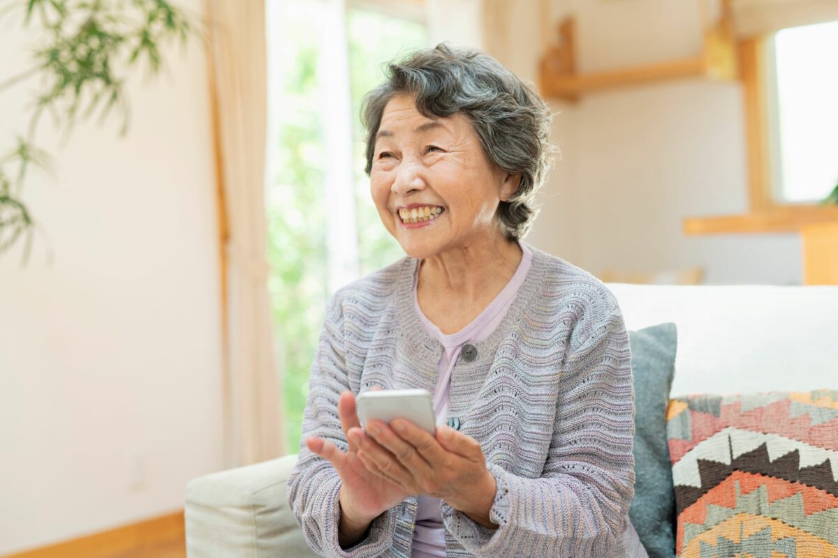 Older woman smiling using cellphone