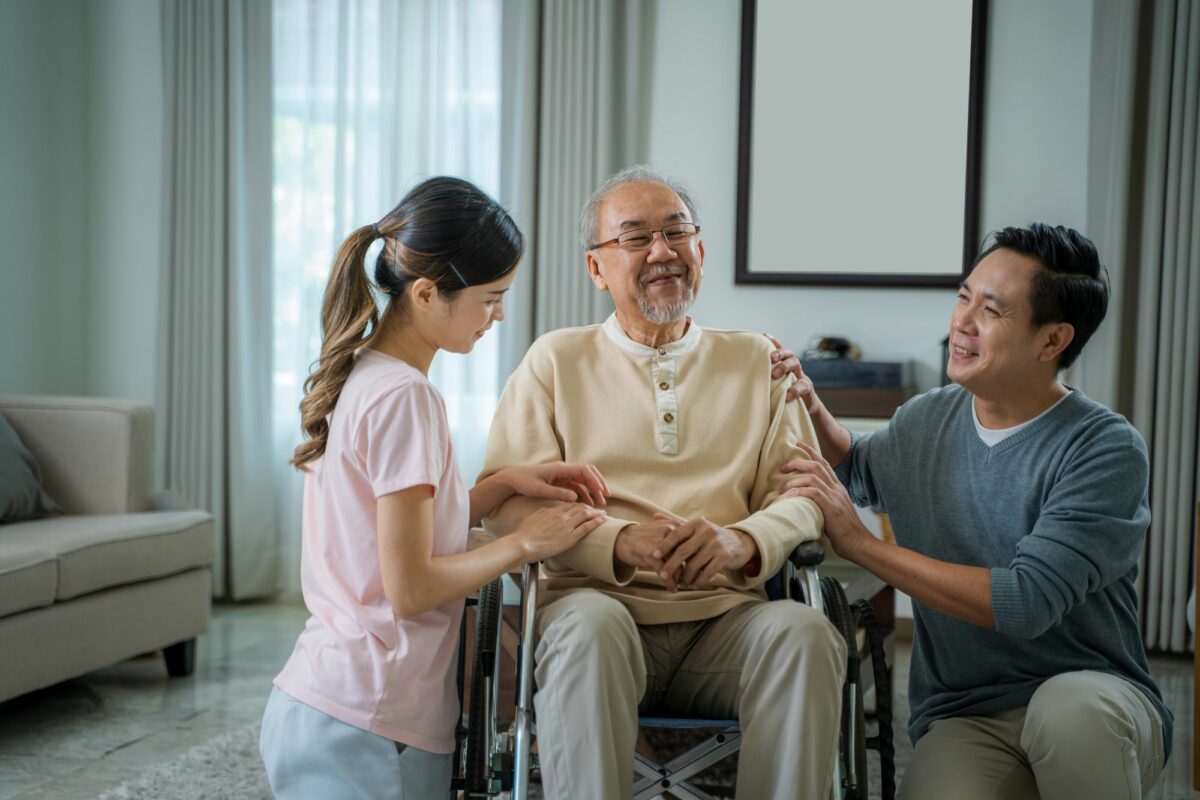 Daughter and son with elderly father in wheelchair